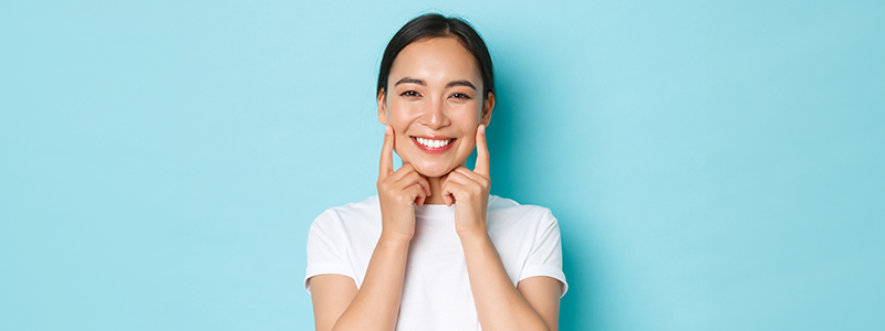 Happy woman with hands on her face, smiling widely.