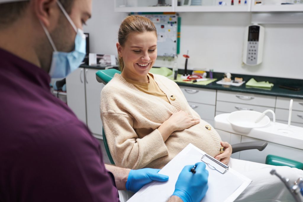 A pregnant woman sitting in a dentist's office