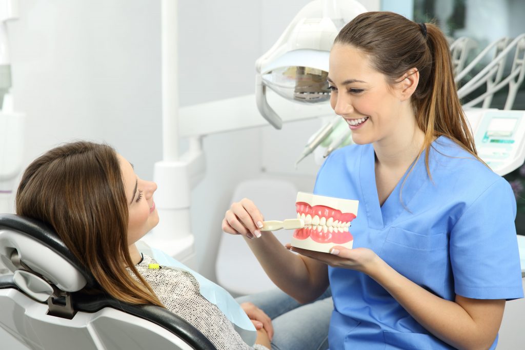 A dentist examining a patient's teeth in a dental office.