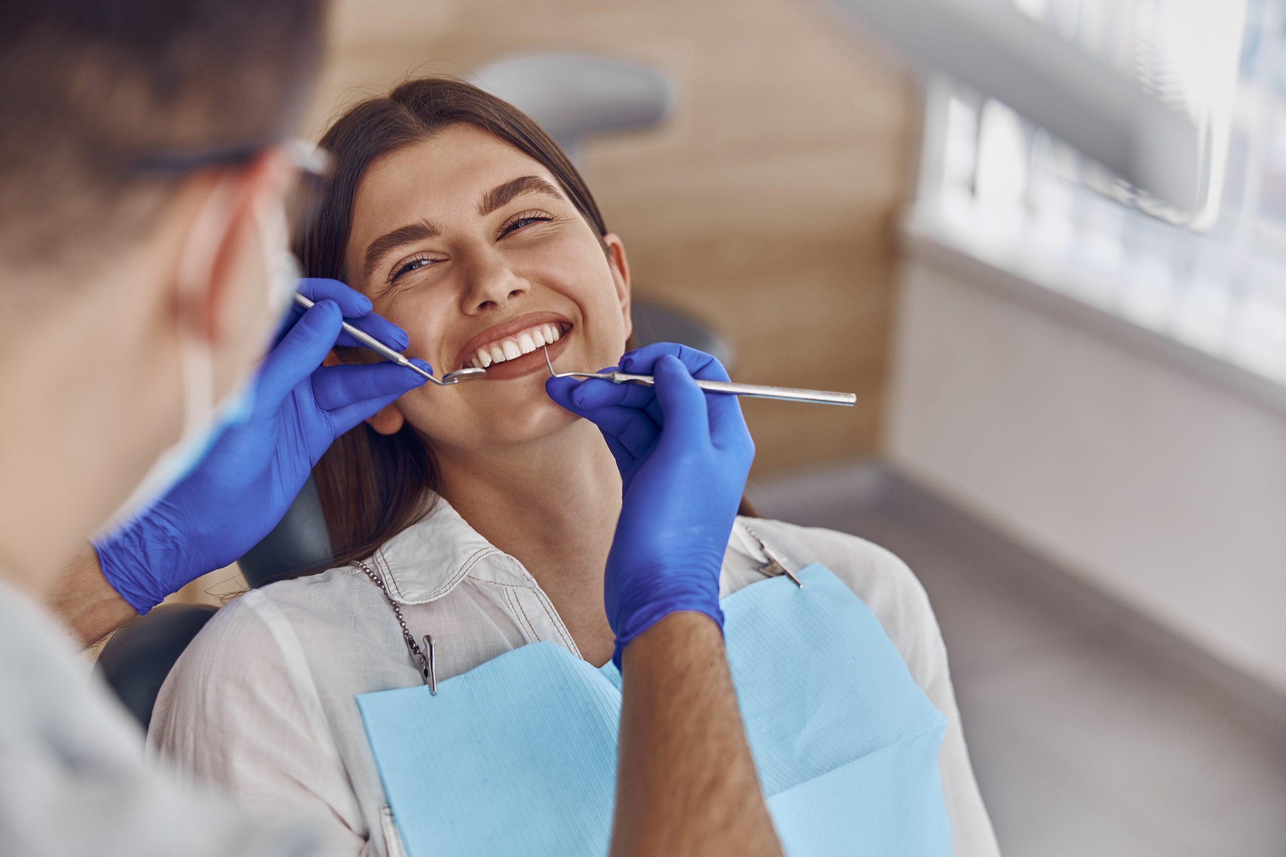 Smiling woman getting her teeth checked by dentist