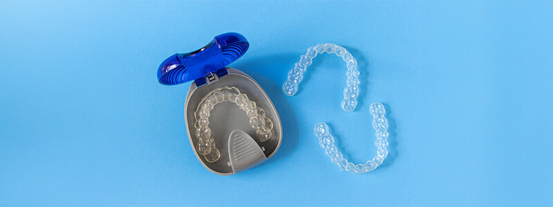 Invisalign in a storage case, with extra Invisalign clear aligners beside 