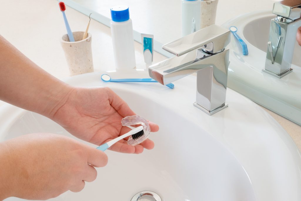 a man cleaning his invisalign